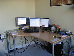A corner office with three online computers